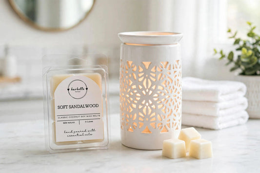 Soft Sandalwood Classic coconut soy wax melts clamshell beside a lit white ceramic wax warmer with loose wax cubes